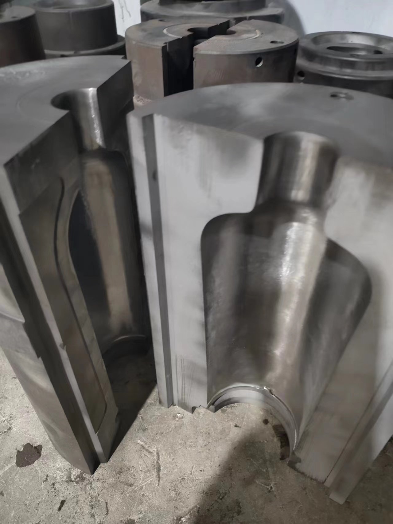 Open steel bottle mold halves showing the bottle cavity—open-mold step in our Custom glass Bottles process.