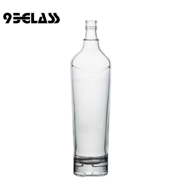 Tall crystal-clear glass whiskey bottle with modern shoulder design for premium spirits.