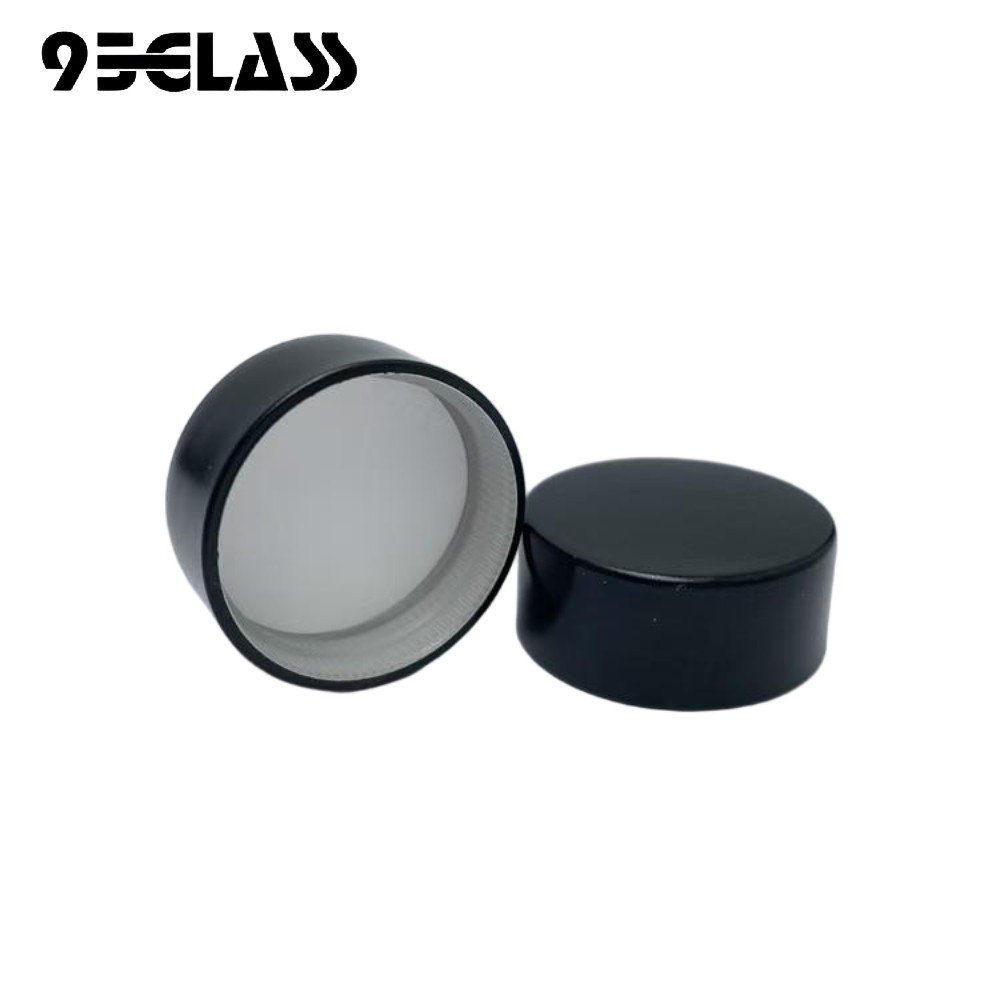 Black plastic screw cap with smooth finish for liquor bottles.